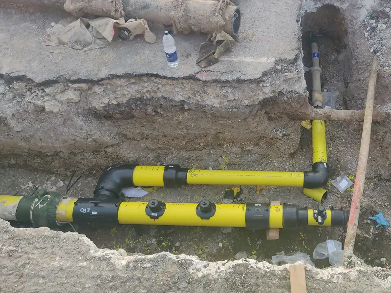 A new yellow gas pipe with branches laid in an open trench