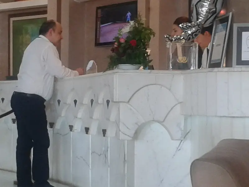 Hotel reception desk in Hammamet, Tunisia, with a guest talking to the staff