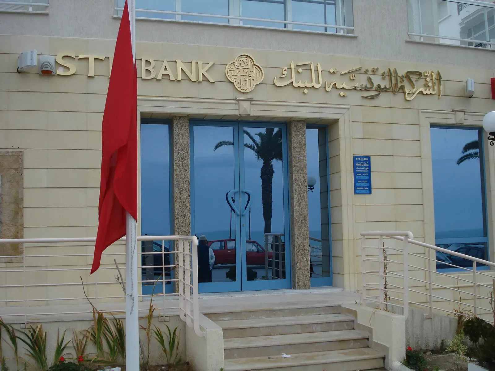 Entrance of an STB bank branch in La Marsa, with its name in Arabic and Latin letters above glass doors