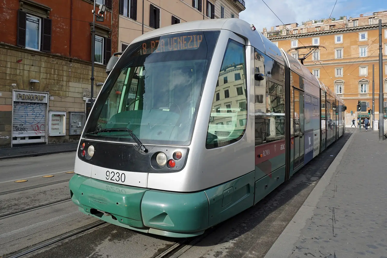 A green and silver line 8 tram at Largo di Torre Argentina in Rome