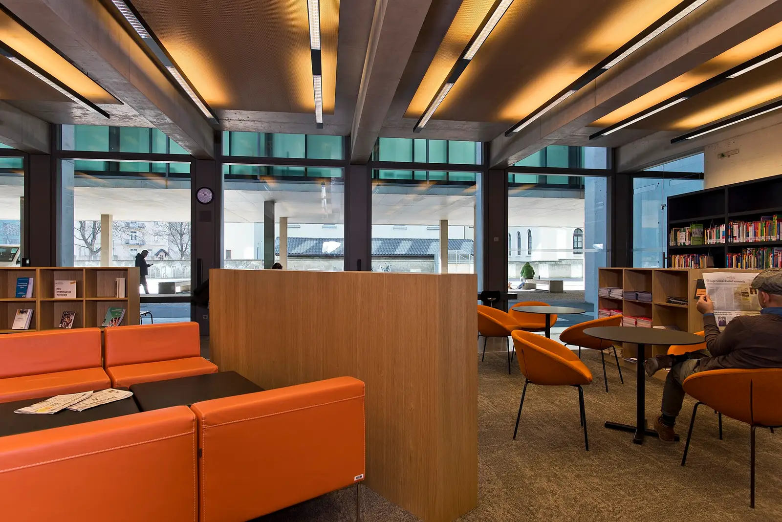 Study area with orange sofas and bookshelves in a university library in Italy